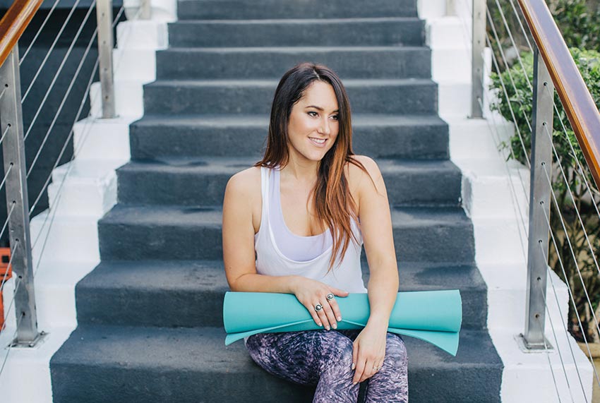 cassie-sitting-on-stairs-yoga-mat